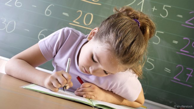 Schülerin macht Aufgaben im Klassenzimmer