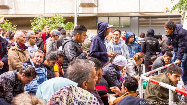 Asylbewerber warten vor einer Behörde