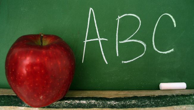 Tablet mit Apfel vor Kreidetafel