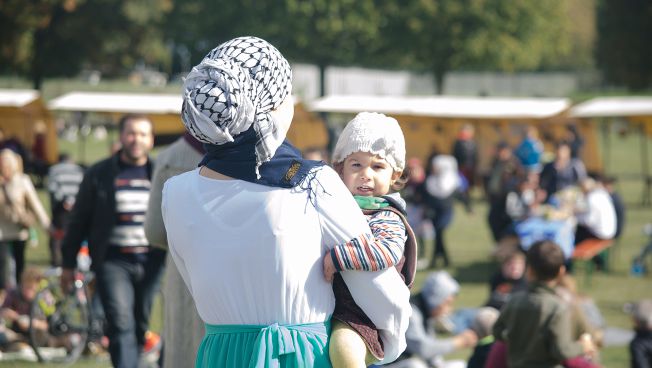 Mutter mit Kind beim Welcome-Picknick in Berlin / Foto: Caitlin Hardee