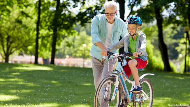 Renter bringt Kind das Fahrradfahren bei